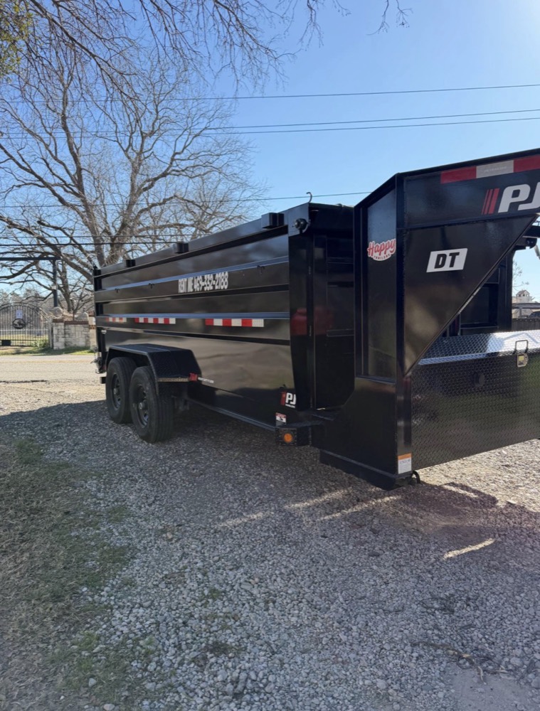 PJ Trailers 15-yard dump trailer parked on gravel, rear view